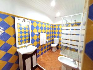 a blue and yellow bathroom with a toilet and a sink at Red House in Alhaurín el Grande +19 photos