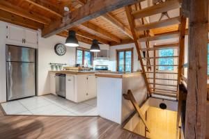 a kitchen with white cabinets and a wooden ceiling at Au Chic Chalet des Chutes Chic Chalet in Sainte-Melanie