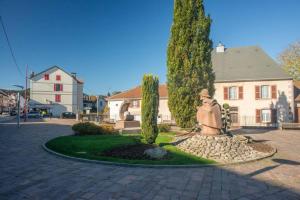 eine Statue in der Mitte eines Gartens vor einem Haus in der Unterkunft Le grand Géromois - Spacious - Private parking in Gérardmer