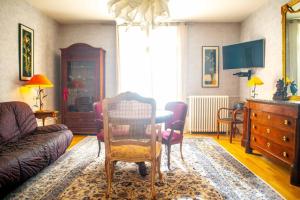 ein Wohnzimmer mit einer Couch und einem Tisch und Stühlen in der Unterkunft Le grand Géromois - Spacious - Private parking in Gérardmer