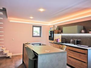 a kitchen with a counter and a kitchen island with chairs at Charmantes Haus im grünen mit Terrasse und Carport in Erfurt