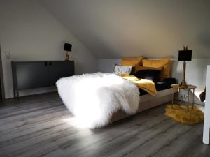 a bedroom with a bed with a white furry couch at Charmantes Haus im grünen mit Terrasse und Carport in Erfurt