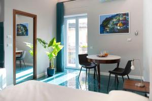 a room with a table and chairs and a mirror at Palazzo De Gregorio Deluxe Room in SantʼAntonio Abate