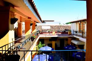 a balcony with umbrellas and tables on a building at Hotel Aldama in Colima +22 photos