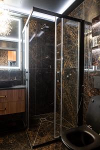 a bathroom with a shower with a toilet and a sink at AMJ Royal Apartments - 115 - Black Rubby in Kaunas