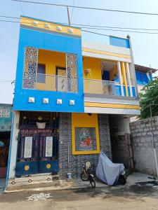 a blue and yellow house with a bike in front of it at La Baie Homestay in Puducherry