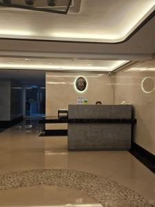 Un vestíbulo con un mostrador de recepción y un reloj en la pared. en Cozy 2BR with Balcony in Mines View Park by Peniel's Getaway, en Baguio