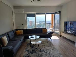 a living room with a couch and a tv at Orange Apartment in Prizren