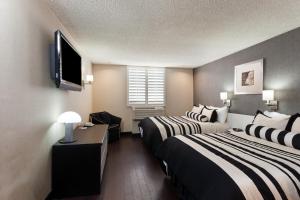 Łóżko lub łóżka w pokoju w obiekcie Ramada Plaza by Wyndham West Hollywood Hotel & Suites