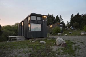 a black tiny house sitting on top of a field at We-Che Tiny houses in Trevelin