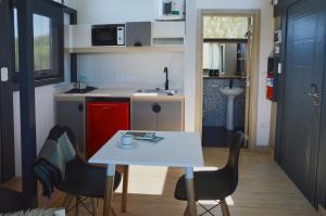 a small kitchen with a white table and chairs at We-Che Tiny houses in Trevelín