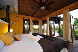 a bedroom with a bed with a ceiling fan at Hacienda Puerta del Cielo Eco Lodge & Spa in Masaya
