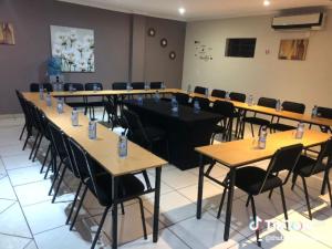 una stanza con file di tavoli e sedie di Thuba Kobo Segole Guesthouse a Kuruman Altre 15 foto
