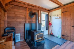 a woodburning stove in a room with wooden walls at Au Chic Chalet des Chutes Chic Rustique in Sainte-Melanie