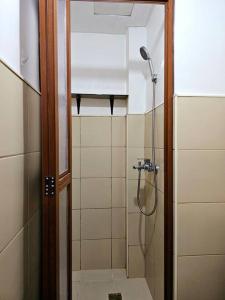 una ducha con puerta de cristal en un baño en Cozy 2BR with Balcony in Mines View Park by Peniel's Getaway, en Baguio