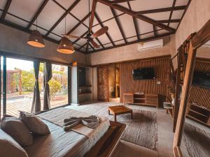 een grote slaapkamer met een groot bed en een televisie bij MAPUWI Villa & Suite in Palomino