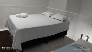 a large bed with white sheets and pillows on it at top residencial 2 in Sinop