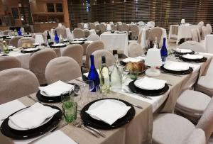 a dining room with tables and chairs with white table settings at Barion Hotel & Congressi in Bari