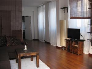 a living room with a couch and a tv on a table at The Back Yard Nest in Lisbon