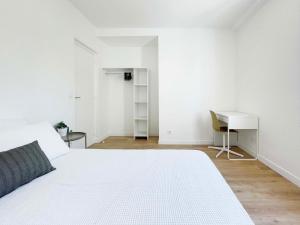a white bedroom with a bed and a desk at Ma Belle Conciergerie - Le Cocon Mélunais in Melun +10 photos
