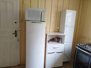 a kitchen with a microwave on top of a refrigerator at Casa central 349 in Ponta Grossa