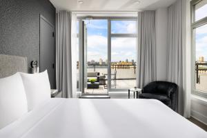 a hotel room with a large bed and a large window at Arthouse Hotel in New York