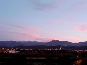 a view of a city and mountains at sunset at Pyrenees Vue Gite - Vues Fantastique, Parking Gratuit Sur Place & Piscine in Saint-Gaudens