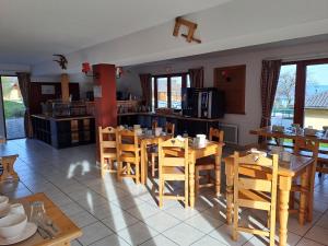 une salle à manger avec des tables et des chaises en bois dans l'établissement Studio entre Lac et Montagnes Evian - Lugrin, à Lugrin