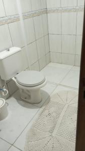 Casas de Aluguel da Lulu في ايتابيما: حمام ابيض مع مرحاض وسجادة +12 صورة