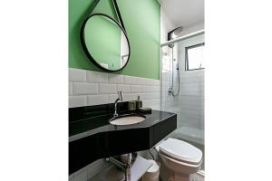 a bathroom with a sink and a mirror at Loft moderno e espaçoso no centro de Floripa -UN30 in Florianópolis +10 photos