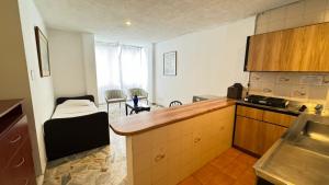 a kitchen with a counter and a room with a bed at Hotel Montecarlo in Cali