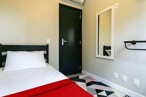 a bedroom with a bed with a black door and a mirror at Loft moderno e espaçoso no centro de Floripa -UN30 in Florianópolis