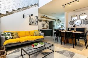 a living room with a yellow couch and a table at Loft moderno e espaçoso no centro de Floripa -UN30 in Florianópolis