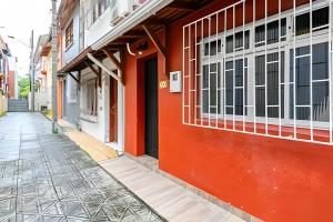 a red building with a door on a street at Casa central em ótima localização - UN059 in Florianópolis