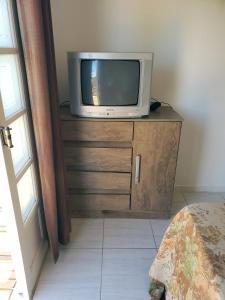 a tv sitting on top of a wooden dresser at Refúgio Minimalista Tranquilidade a 600m da Praia in Governador Celso Ramos