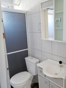 a bathroom with a white toilet and a sink at Refúgio Minimalista Tranquilidade a 600m da Praia in Governador Celso Ramos +16 photos