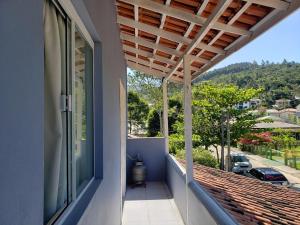 a balcony with a wooden pergola overlooking a street at Refúgio Minimalista Tranquilidade a 600m da Praia in Governador Celso Ramos