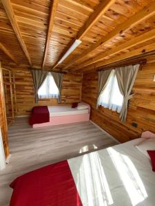 a bedroom with two beds in a log cabin at Karatürkmen Wooden Villas in Demre