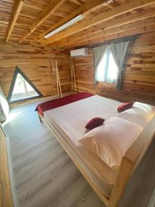 a bedroom with a bed in a wooden cabin at Karatürkmen Wooden Villas in Demre