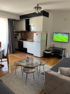 Una sala de estar con un sofá y una mesa y una cocina. en Barbaros Apartment, en Ohrid
