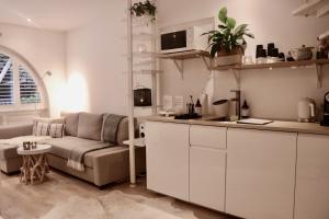 a living room with a couch and a kitchen at Cavalli's Cottage in Bilthoven