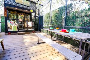 a patio with a table with bowls on it at FunTropicalTinyHomeGolfCartLake in Orlando