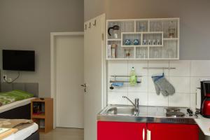 a kitchen with a sink and a red cabinet at Ferienwohnung Prinke in Niedertrebra