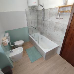 a bathroom with a shower and a toilet and a tub at Appartamento Verde Lago Ledro in Molina di Ledro
