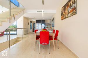 ein Esszimmer mit einem Tisch und roten Stühlen in der Unterkunft Villa Alex by Abahana Villas in Benissa