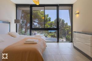 ein Schlafzimmer mit einem Bett und einem großen Fenster in der Unterkunft Villa Alex by Abahana Villas in Benissa + 18 Fotos