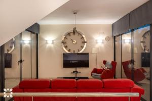 ein Wohnzimmer mit einer roten Couch und einer Uhr in der Unterkunft Villa Alex by Abahana Villas in Benissa