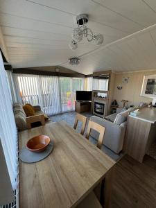 a living room with a wooden table and a couch at Flower Bay in Prestatyn