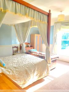 a bedroom with a canopy bed and a window at Portland House in Whitchurch +16 photos