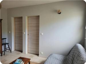 a living room with two wooden doors and a table at La petite maison in Pontis